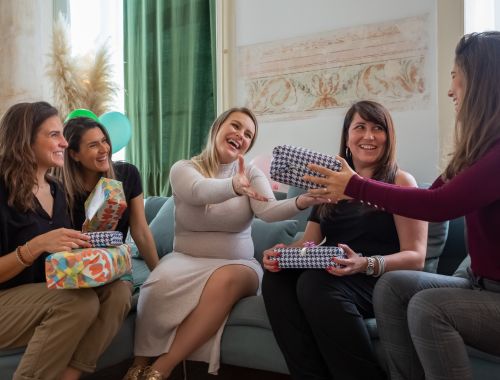 mujeres reunidas en un linving recibiendo regalos