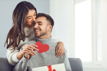 Mujer entrega regalo de enamorados a su pareja hombre