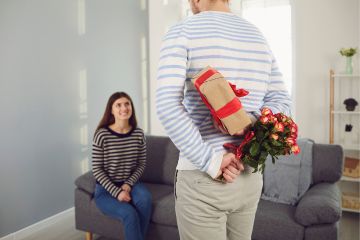 Hombre sorprendiendo a su pareja con regalo de aniversario