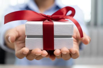 Primer plano de regalo sostenido con las dos manos de un hombre